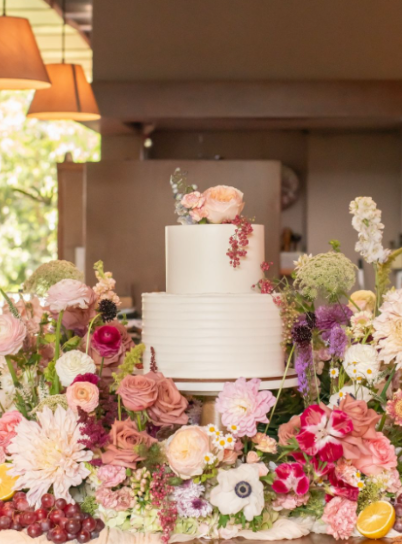 Floral arrangement for a wedding, side to side with a wedding cake